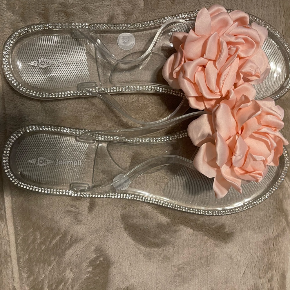 Jolimall clear plastic flip flop with pink flowers.